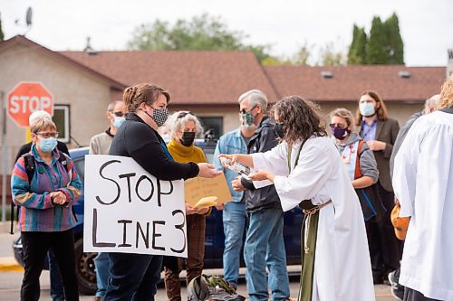 MIKE SUDOMA / Winnipeg Free Press
Priest, Gwen McAllister, sanitizes a supporters hands Saturday as they take part in communion in the parking lot of a TD Bank location on St Annes Rd in protest of the companys support in the Line 3 Pipeline project as well as other fossil fuel related projects.
September 25, 2021