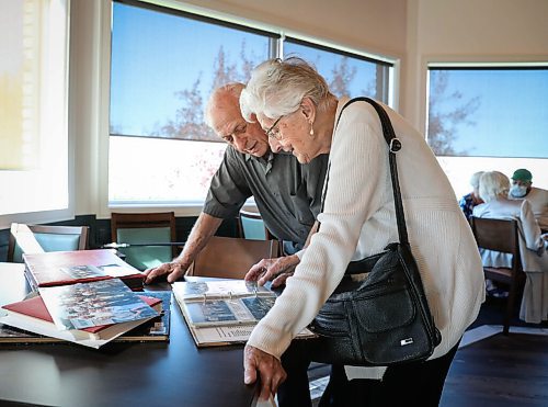 JESSICA LEE / WINNIPEG FREE PRESS

Martha Neufeld and John Sukkau look at photos of past get-togethers on September 22, 2021 at Larters at St. Andrews Golf and Country Club during the last Club 56 meet-up.

In 1956, 14 couples from Winnipeg married and formed a club they called Club 56. They have been meeting every year since 1956, however this meeting is their last meeting because the members are aging and some have moved out of the province. The original group of 28 is now a group of 14 as some members have passed away or moved out of province.

Reporter: Ben