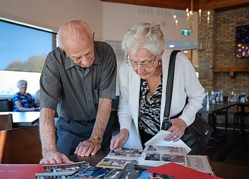 JESSICA LEE / WINNIPEG FREE PRESS

Martha Neufeld and John Sukkau look at photos of past get-togethers on September 22, 2021 at Larters at St. Andrews Golf and Country Club during the last Club 56 meet-up.

In 1956, 14 couples from Winnipeg married and formed a club they called Club 56. They have been meeting every year since 1956, however this meeting is their last meeting because the members are aging and some have moved out of the province. The original group of 28 is now a group of 14 as some members have passed away or moved out of province.

Reporter: Ben