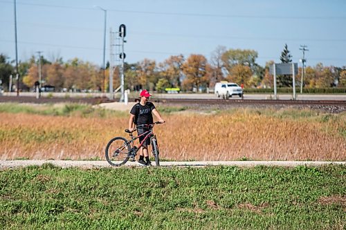 MIKAELA MACKENZIE / WINNIPEG FREE PRESS

Evan McRae, 13, bikes out to shoot photos and record video of trains east of Symington Yards in Winnipeg on Monday, Sept. 27, 2021.  For the last two years, the young rail fan has been going out to watch trains around the city. For --- story.
Winnipeg Free Press 2021.