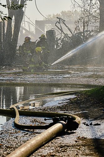 MIKE DEAL / WINNIPEG FREE PRESS
Firefighters work to extinguish hot spots from a warehouse fire in Point Douglas early Wednesday morning.
210929 - Wednesday, September 29, 2021.