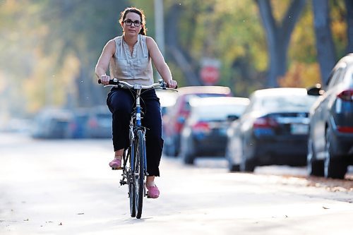 JOHN WOODS / WINNIPEG FREE PRESS
Mel Marginet, a co-ordinator of workplace commuter options at Green Action Centre, rides her bike on her street in Winnipeg Thursday, September 30, 2021. City councillor Matt Allard is calling for the city to increase its dedicated active transportation funding from $2 million per year to $15 million per year.

Reporter: Pursaga
