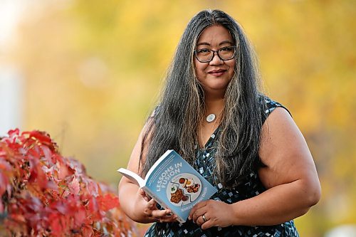 JOHN WOODS / WINNIPEG FREE PRESS
Primrose Madayag Knazan, Winnipeg social media food influencer, is photographed with her new book on her street in Winnipeg Thursday, September 30, 2021. Madayag Knazan has written a young adult novel about a young Filipinx woman who is coming to terms with her cultural identity through food and cooking.

Reporter: Wasney
