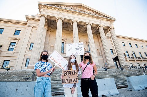 MIKE SUDOMA / Winnipeg Free Press
(Left to right) Sienna, Gabby, and Kat hold up signs as they take part in the Rally for Reproductive Rights at the Manitoba Legislative Building Saturday
October 2, 2021