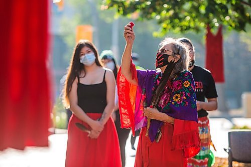 MIKAELA MACKENZIE / WINNIPEG FREE PRESS

Elder Carolyn Moar raises a tobacco tie at a sacred fire at City Hall in honour of a day of action and awareness for missing and murdered Indigenous women, girls, and two-spirited peoples in Winnipeg on Monday, Oct. 4, 2021. For --- story.
Winnipeg Free Press 2021.