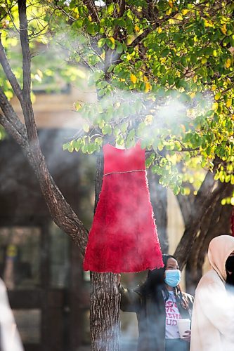 MIKAELA MACKENZIE / WINNIPEG FREE PRESS

Red dresses hang in the courtyard as smoke from a sacred fire drifts past at City Hall in honour of a day of action and awareness for missing and murdered Indigenous women, girls, and two-spirited peoples in Winnipeg on Monday, Oct. 4, 2021. For --- story.
Winnipeg Free Press 2021.