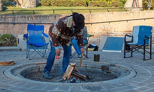 MIKE DEAL / WINNIPEG FREE PRESS
Stan La Pierre adds a few logs to the sacred fire that was lit early Monday morning during a sunrise ceremony at Oodena Celebration Circle which kicked off events acknowledging missing and murdered Indigenous women, girls and gender-diverse people.
211004 - Monday, October 04, 2021.