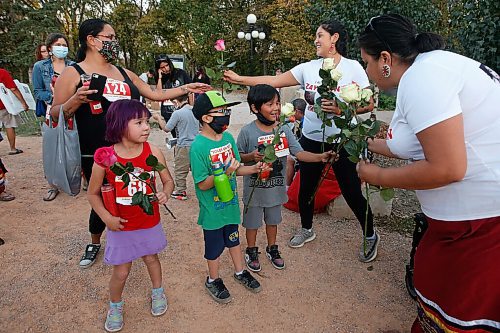 JOHN WOODS / WINNIPEG FREE PRESS
Leeah Lavallee, right, and her daughter Taylor Lavallee hand out flowers to people in memory of her niece Zaylynn who died at 9 months as people gather for a vigil and place candles around the Murdered and Missing Women and Girls (MMIWG) monument at the Forks during MMIWG day in Winnipeg Monday, October 4, 2021. 

Reporter: May