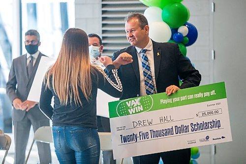 MIKAELA MACKENZIE / WINNIPEG FREE PRESS

Advanced education, skills and immigration minister Wayne Ewasko elbow-bumps scholarship winner Drew Hall at a Vax to Win event at the RBC Convention Centre vaccination supersite in Winnipeg on Tuesday, Oct. 5, 2021. For Gabby story.
Winnipeg Free Press 2021.