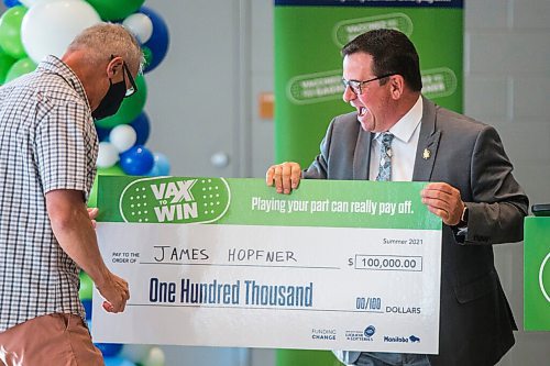 MIKAELA MACKENZIE / WINNIPEG FREE PRESS

Crown services minister Jeff Wharton congratulates winner James Hopfner at a Vax to Win event at the RBC Convention Centre vaccination supersite in Winnipeg on Tuesday, Oct. 5, 2021. For Gabby story.
Winnipeg Free Press 2021.