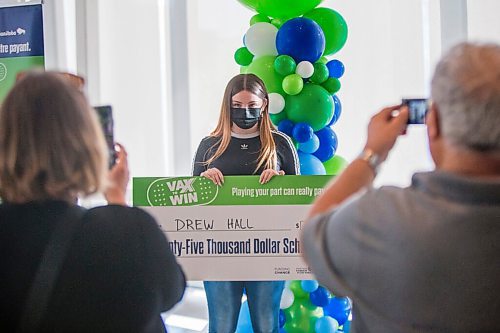 MIKAELA MACKENZIE / WINNIPEG FREE PRESS

Vax to Win scholarship winner Drew Hall takes a photo with her novelty cheque after the announcement at the RBC Convention Centre vaccination supersite in Winnipeg on Tuesday, Oct. 5, 2021. For Gabby story.
Winnipeg Free Press 2021.