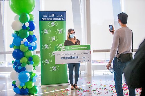 MIKAELA MACKENZIE / WINNIPEG FREE PRESS

Vax to Win winner Michaelle Cruz takes a photo with her novelty cheque after the announcement at the RBC Convention Centre vaccination supersite in Winnipeg on Tuesday, Oct. 5, 2021. For Gabby story.
Winnipeg Free Press 2021.