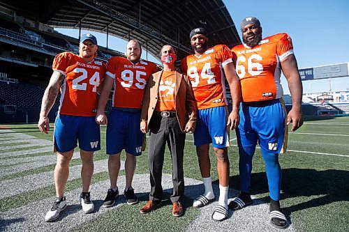 JOHN WOODS / WINNIPEG FREE PRESS
AMC grand chief Arlen Dumas, centre, is photographed with, from left, Blue Bombers Mike Miller (24), Jake Thomas (95), Jackson Jeffcoat (94) and Stanley Bryant (66) in the stadium at a Blue Bomber orange jersey launch at the Blue Bomber stadium in Winnipeg Tuesday, October 5, 2021. Wade Miller and the Winnipeg Blue Bombers unveiled a special orange jersey that will be worn by both the Blue Bombers and Elks for pre-game warmup this Friday, to recognize Orange Shirt Day. 

Reporter: Allen
