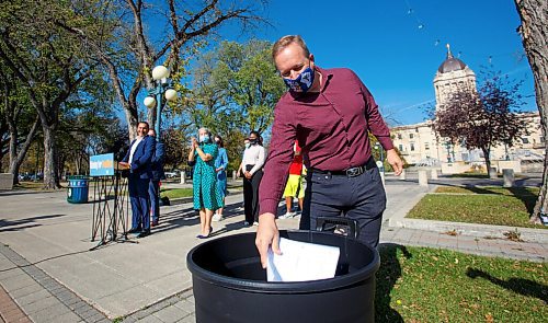 MIKE DEAL / WINNIPEG FREE PRESS
Kevin Rebeck, president of the Manitoba Federation of Labour, throws a copy of the labour bill into the trash during a media call by NDP leader Wab Kinew who was celebrating the removal of five government bills from the agenda. Wab was joined by parents, teachers, hydro workers and representatives from CUPE, MGEU and MFL Wednesday morning on the grounds of the Manitoba Legislative building.
211006 - Wednesday, October 06, 2021.