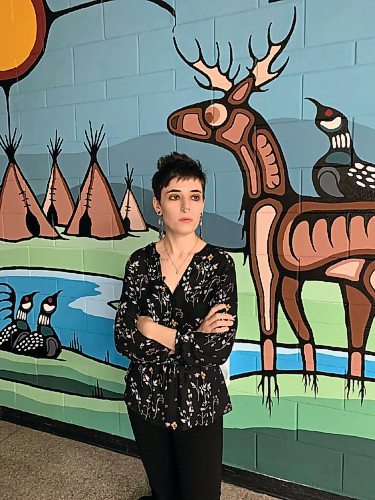 Canstar Community News Justine Proulx, pictured with some of the artwork she has created in the hallways of the Louis Riel School Division Arts and Technology Centre.