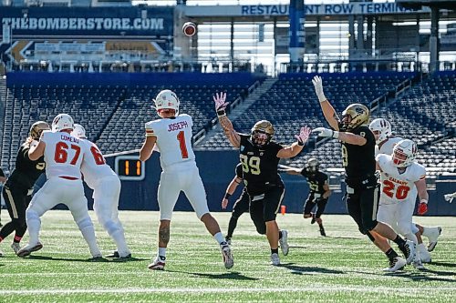 Daniel Crump / Winnipeg Free Press. Bisons Collin Kornelson (99) throws his arms up to try and block a throw early in the game. University of Manitoba Bisons take on the University of Calgary Dinos at IG Field in Winnipeg. October 16, 2021.