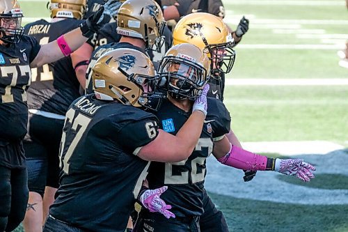 Daniel Crump / Winnipeg Free Press. The Bisons celebrate a touchdown to take the lead after Breydon Stubbs (22) carried the ball over the line to take a late game lead. University of Manitoba Bisons take on the University of Calgary Dinos at IG Field in Winnipeg. October 16, 2021.