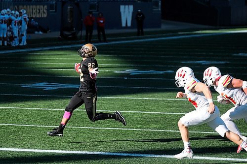 Daniel Crump / Winnipeg Free Press. Bisons running back Breydon Stubbs (22) runs the ball over the line to complete a late game comeback. University of Manitoba Bisons take on the University of Calgary Dinos at IG Field in Winnipeg. October 16, 2021.
