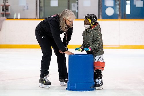 Daniel Crump / Winnipeg Free Press. Shelly Harms (left) helps Alhousena Abdoulaye (right) learn to skate as they take part in the Winnipeg Newcomer Sport Academy at Charlie Gardiner Arena on Saturday morning. The Academy is a not for profit organization in Winnipeg dedicated to getting kids involved in sport who are new to Canada. October 16, 2021.