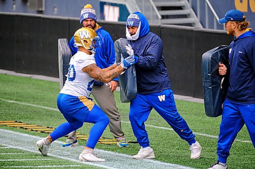 MIKE DEAL / WINNIPEG FREE PRESS
Winnipeg Blue Bombers Brady Oliveira (20) and a sidelined Andrew Harris during practice at IG Field Tuesday morning.
211019 - Tuesday, October 19, 2021.