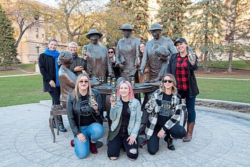 MIKE SUDOMA / Winnipeg Free Press
(Left to right) Brooklyn Krul, Cory Krul, Kyla Dumanski, Josie Cannon, Danielle Strachan, Shelby Guthrie, and Erica Campbell hold up Torques new beer Whoa Nellie in front of the Group of 5 statue on the Manitoba Legislative Grounds Wednesday
October 20, 2021