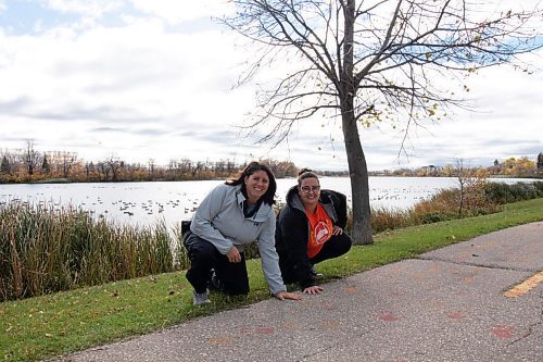 Canstar Community News Oct. 19, 2021 - Jill Fast (left) and Megan Romphf have partnered with eight schools in the Portage La Prairie School Division to have classrooms join in the Paving the way for Reconciliation project. 8,895 handprints were painted in red and orange across Crescent Road and parts of the community over the month of October. (JOSEPH BERNACKI/CANSTAR COMMUNITY NEWS/HEADLINER)