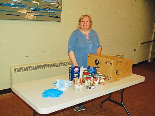 Canstar Community News Sharon Vandenberg, office administrator at Immanuel United Church, readies wares for the churchs food bank, which operates every second Monday.