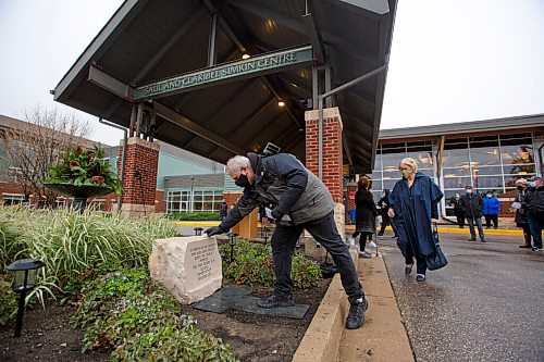 MIKE DEAL / WINNIPEG FREE PRESS
Brian Shuster places a stone on top of the memorial dedicated to the eleven residents, including his mother, Esther Shuster, who died of Covid-19. 
The Saul and Claribel Simkin Centre personal care home (1 Falcon Ridge Drive) dedicated a permanent stone memorial to the eleven residents who died of COVID-19 during the pandemic Wednesday morning.
See John Longhurst story
211027 - Wednesday, October 27, 2021.