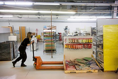 MIKE DEAL / WINNIPEG FREE PRESS
Employee, Haley Bean, moves a display of paints in the new retail area of the new location for Artists Emporium at 580 Roseberry Street.
211101 - Monday, November 01, 2021.
