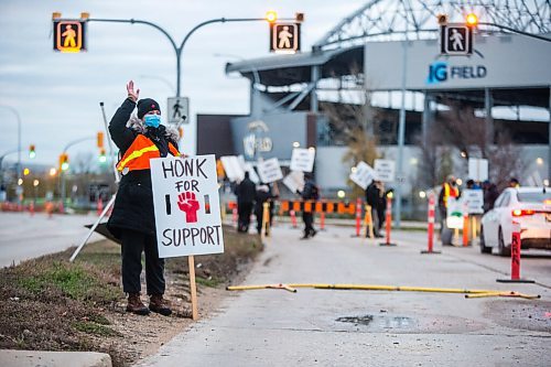 MIKAELA MACKENZIE / WINNIPEG FREE PRESS

Leilanie Clayton, anatomy instructor, waves at traffic while on the picket line on University Crescent at the University of Manitoba in Winnipeg on Tuesday, Nov. 2, 2021. For Maggie story.
Winnipeg Free Press 2021.