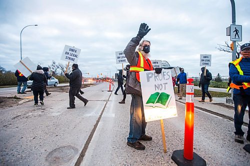 MIKAELA MACKENZIE / WINNIPEG FREE PRESS

James Hare, professor emeritus of biological sciences, intermittently stops traffic while on the picket line on University Crescent at the University of Manitoba in Winnipeg on Tuesday, Nov. 2, 2021. For Maggie story.
Winnipeg Free Press 2021.