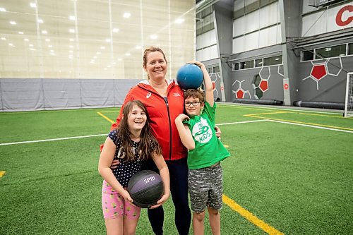 Mike Sudoma / Winnipeg Free Press
Melanie Gregg (centre) an instructor with the Manitoba Athletics track and field program for inner city kids, and her two children Tessa and Ryder Pillipow  who are in the program Tuesday night at the Axworthy Health and Recplex
November 2, 2021