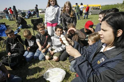 MIKE.DEAL@FREEPRESS.MB.CA 100520 - Thursday, May 20th, 2010 OPASKWAYAK CREE NATION Mrs. Cable shows her grade five students from Kellsey Community School how to prepare bannock on a stick a the traditional camp and community feast hosted by Joe E. Ross School.  See Nick Martin story. MIKE DEAL / WINNIPEG FREE PRESS