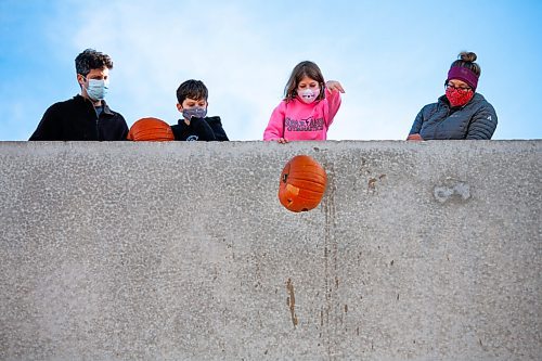 Daniel Crump / Winnipeg Free Press. A kid tosses their pumpkin from the second story of the Polo Park parkade Saturday morning as part of the Compost Manitoba Pumpkin Drop. The pumpkins are later composted or donated to local farm as feed for animals. November 6, 2021.