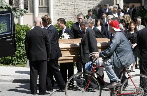 MIKE.DEAL@FREEPRESS.MB.CA 100603 - Thursday, June 3nd, 2010 A bicyclist rides by on Broadway as Duff Roblin's casket is put into a hearse after the funeral service at All Saints' Anglican Church Thursday morning. Former premier Duff Roblin died Sunday in hospital after a brief illness. He was 92. MIKE DEAL / WINNIPEG FREE PRESS