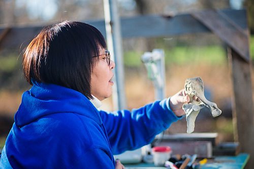 MIKAELA MACKENZIE / WINNIPEG FREE PRESS

Inuit carver Goota Ashoona, who comes from a long line of artists and whose scupture lives outside of Qaumajuq, carves whalebone in her yard near Elie on Tuesday, Nov. 9, 2021. For Jen story.
Winnipeg Free Press 2021.