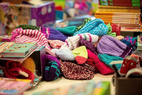 Mike Sudoma / Winnipeg Free Press
Childrens books and winter clothing sit on a work table ready to be wrapped and donated at the Christmas Cheer Boards Headquarters Wednesday
November 10, 2021