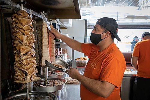 JESSICA LEE / WINNIPEG FREE PRESS

Badis Maymoni carves off chicken which spins on the spit at Baraka Bakery on November 10, 2021.






