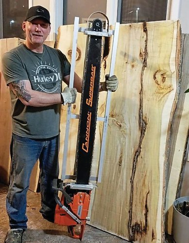Canstar Community News Greg Flett poses with his saw in his workshop at Timber Wülf Live Edge.