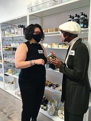 Canstar Community News Marisa Loreno shows Abigaïl Theano-Pudwill, owner of Auxvoir Style Collective, some products during a recent clothing swap at Refill Zero Waste Market on Notre Dame Avenue.