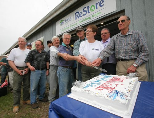 Brandon Sun Long-time volunteers with Habitat for Humanity join volunteer Cheryl Tripp in cutting the cake at Habit's ReStore grand opening on Thursday afternoon. (Bruce Bumstead/Brandon Sun)