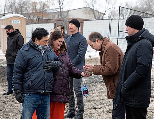 JESSICA LEE / WINNIPEG FREE PRESS

Alison Dong (in orange), a knowledge keeper, blesses the site at 390 Ross Ave by offering smudging to John Pollard, President of Home First Winnipeg Inc. on November 22, 2021. Home First Winnipeg Inc is building a 47-unit apartment for those at risk of becoming homeless.