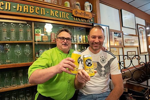 Mike Sudoma / Winnipeg Free Press
Chef Craig Geunther (left) and Bernhard Wieland of Schnitzelhaus, cheers a couple of beers brewed and canned by Bernhard inside of the German Society of Winnipeg building Wednesday
November 24, 2021