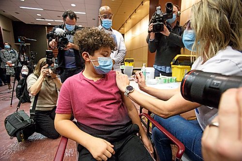 MIKE DEAL / WINNIPEG FREE PRESS
Donovan Bullard, 11, watches the needle as Dr. Joss Reimer, medical lead, Vaccine Implementation Task Force gives him a COVID-19 vaccination, during a press event, at the RBC Convention Centre Supersite, Thursday afternoon.
Manitoba is beginning to immunize children ages five to 11 against COVID-19 this week and thousands of parents have already booked appointments to protect their younger children during the fourth wave of the pandemic and into the holiday season, Health and Seniors Care Minister Audrey Gordon announced today. 
To help mark the launch of the vaccine campaign, six Manitoba children, joined by their family members for support, received their first dose of the pediatric Pfizer vaccine at the RBC Convention Centre super site in Winnipeg.
211125 - Thursday, November 25, 2021.