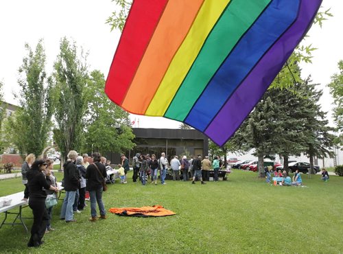 Brandon Sun 12062010 A Pride flag flaps in the breeze as visitors mingle on the Brandon City Hall lawn during Brandon's third annual Pride event on Saturday afternoon. The event included refreshments, entertainment, information on community resources and games for children. (Tim Smith/Brandon Sun)