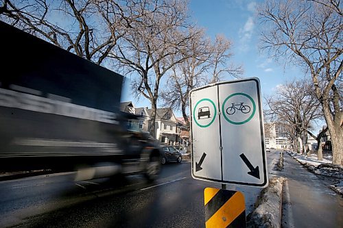 SHANNON VANRAES / WINNIPEG FREE PRESS
Traffic rushes by signage marking a cycle route on Sherbrook St. November 27, 2021.