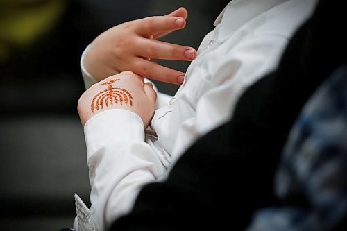 JOHN WOODS / WINNIPEG FREE PRESS
A boy is photographed with a glitter menorah on his hand at a menorah lighting ceremony during a community Chanukah celebration at Chabad-Lubavitch in Winnipeg on Sunday, November 28, 2021. 

Re: standup