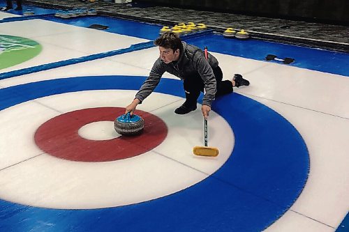 Canstar Community News Luke Robins slides across the ice as he takes his shot with the West Kildonan curling squad.