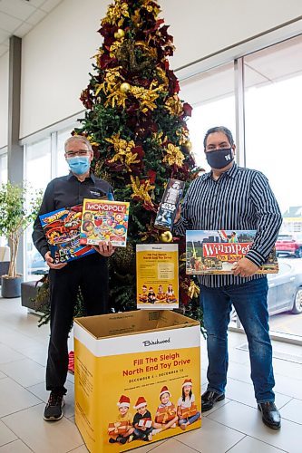 MIKE DEAL / WINNIPEG FREE PRESS
Kyle Mason (right) with Jeff Bachelor (left), GM at Birchwood Honda Regent, 1401 Regent Avenue West and one of the drop-off bins for his toy drive.
Kyle Mason is a lifelong North End resident who has hosted a North End Christmas party for nearly a decade. COVID has prevented him from holding an in-person event, so he has instead organized a toy drive. After growing up in a single parent home, he knows the pain of waking up without presents on Christmas. He has made it his mission to get 900 toys in the hands of children this year.
211130 - Tuesday, November 30, 2021.