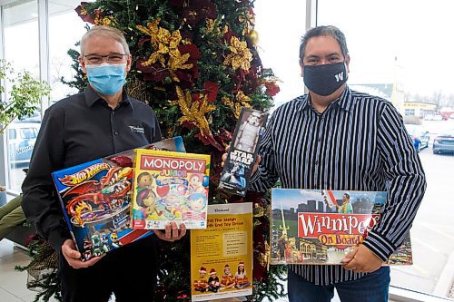 MIKE DEAL / WINNIPEG FREE PRESS
Kyle Mason (right) with Jeff Bachelor (left), GM at Birchwood Honda Regent, 1401 Regent Avenue West and one of the drop-off bins for his toy drive.
Kyle Mason is a lifelong North End resident who has hosted a North End Christmas party for nearly a decade. COVID has prevented him from holding an in-person event, so he has instead organized a toy drive. After growing up in a single parent home, he knows the pain of waking up without presents on Christmas. He has made it his mission to get 900 toys in the hands of children this year.
211130 - Tuesday, November 30, 2021.